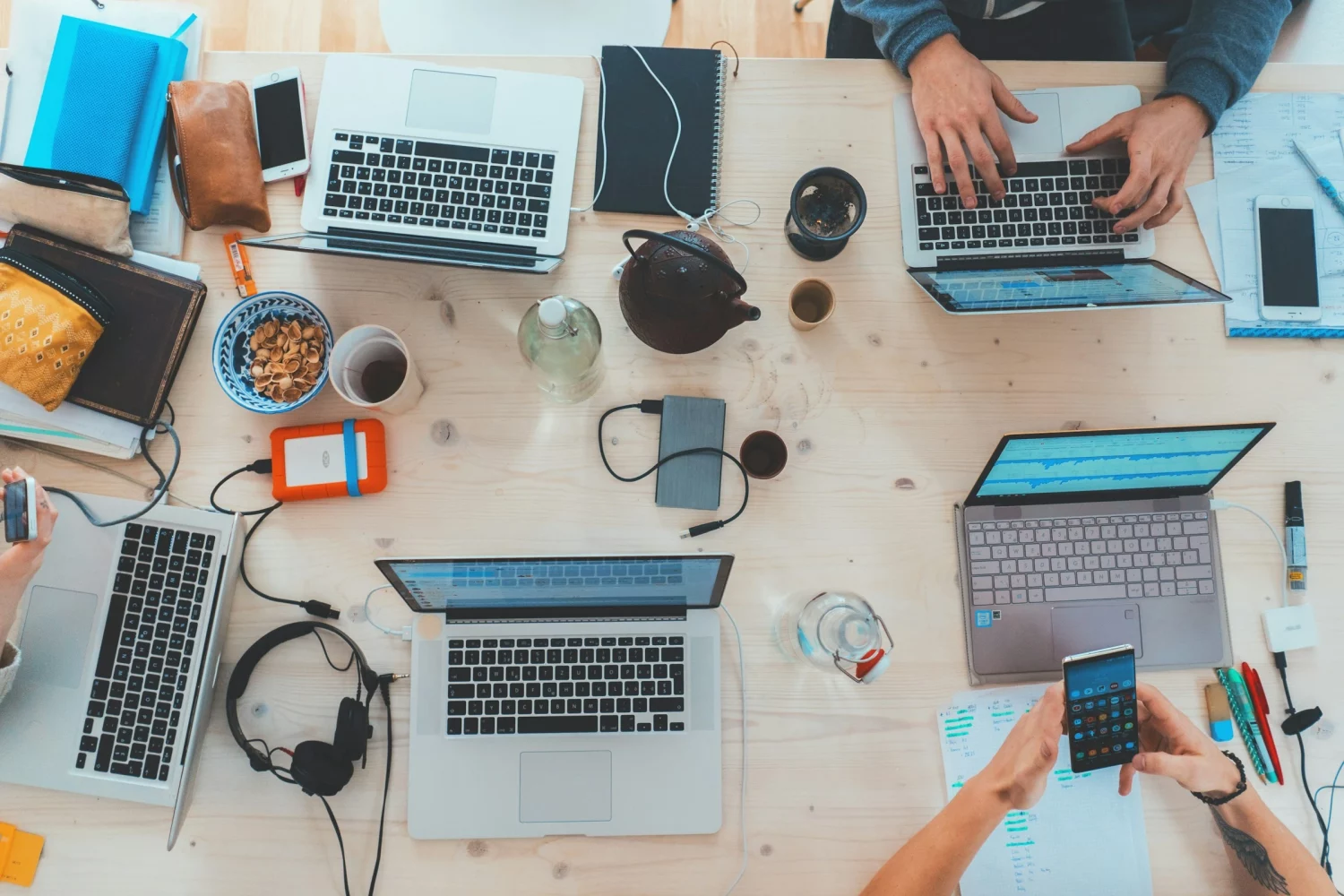 Team di lavoro con laptop e smartphone su una scrivania condivisa
