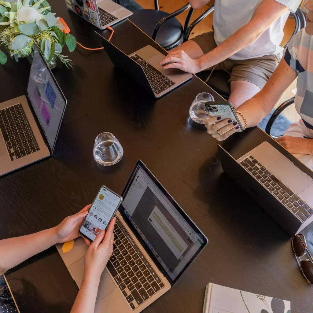 Persone al lavoro sui social media da laptop e smartphone